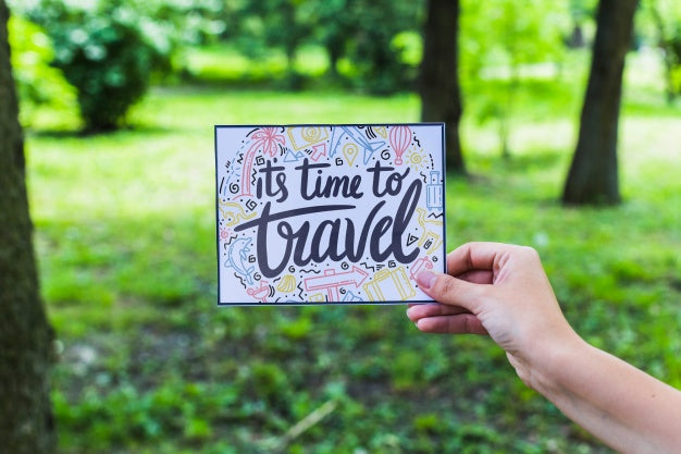 Hand Holding Paper In Nature For Travel Concept Psd