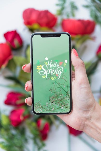 Hand Holding Smartphone Mockup Above Flowers Psd