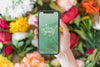 Hand Holding Smartphone Mockup Above Flowers Psd