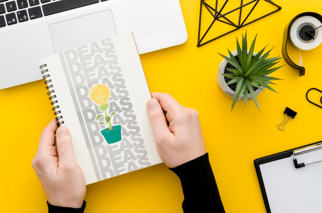Hands Holding Notebook Mock-Up Over Desk Psd