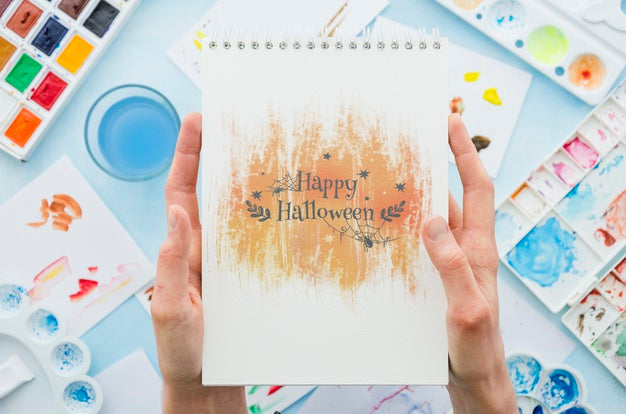 Hands Holding Notebook With Halloween Message Psd