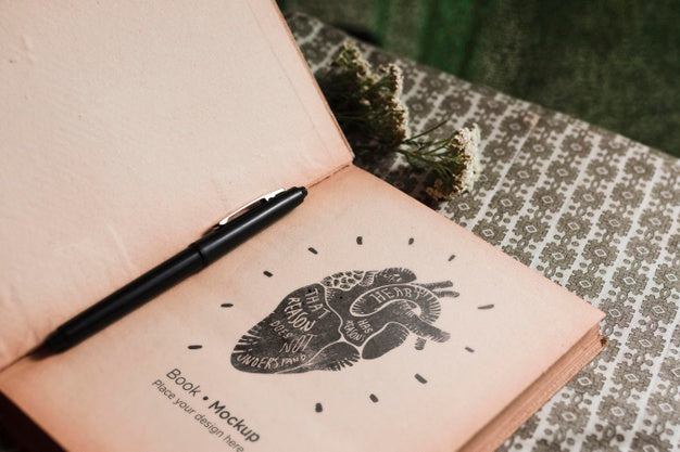 High Angle Of Book With Flowers And Pen Psd