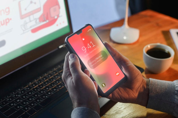 High Angle Of Man Holding Smartphone While At Desk Psd