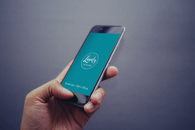 iPhone Mockup in Mans Hand with Gray Background
