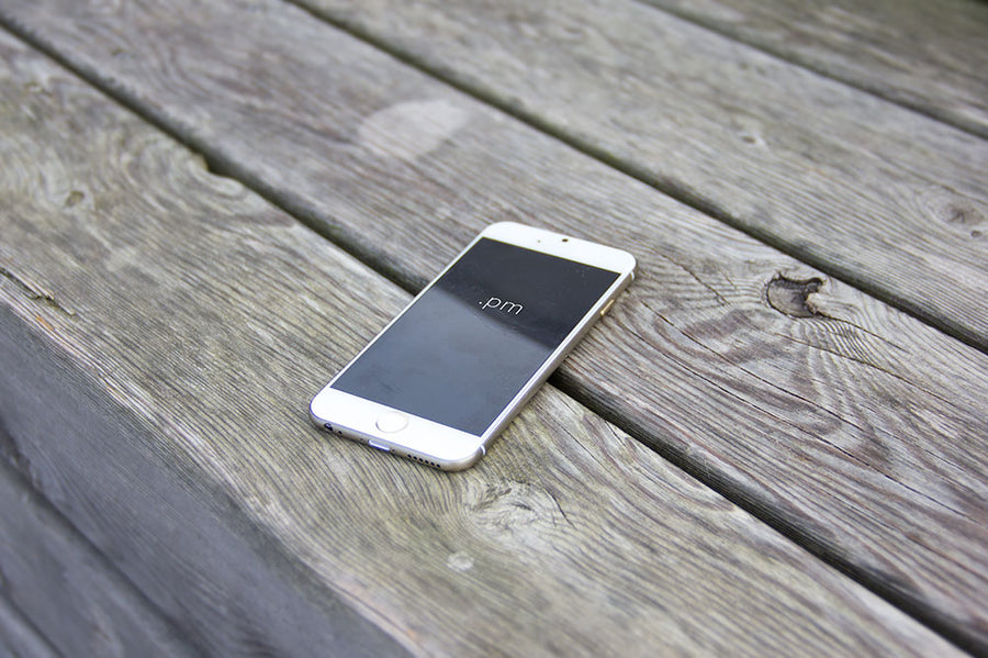 White iPhone 6 on a Wooden Table PSD Mockup