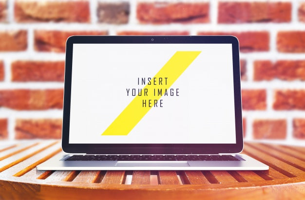 Laptop On Wooden Table In Front Of Brick Wall Mock Up Psd