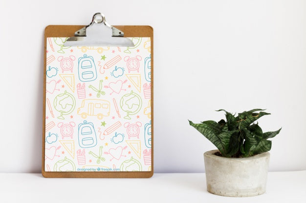 Leaning Clipboard Next To A Plant Psd