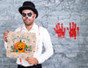 Male With Make-Up Holding A Card With Pumpkin For Halloween Psd