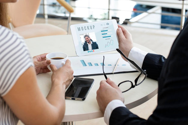 Man And Woman Looking At A Tablet At Work Psd