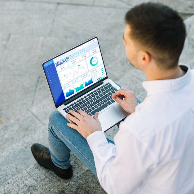 Man Holding A Mock-Up Laptop Outdoors Psd