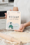 Man Holding Book While Rolling Dough In The Kitchen Psd