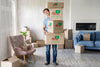 Man Holding Boxes With Objects In His New House Long View Psd
