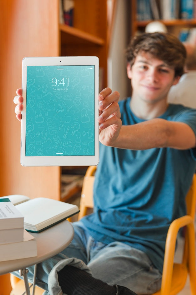 Man Holding Smartphone Mockup In Library Psd