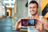 Man In Gym Holding Smartphone Mockup Psd