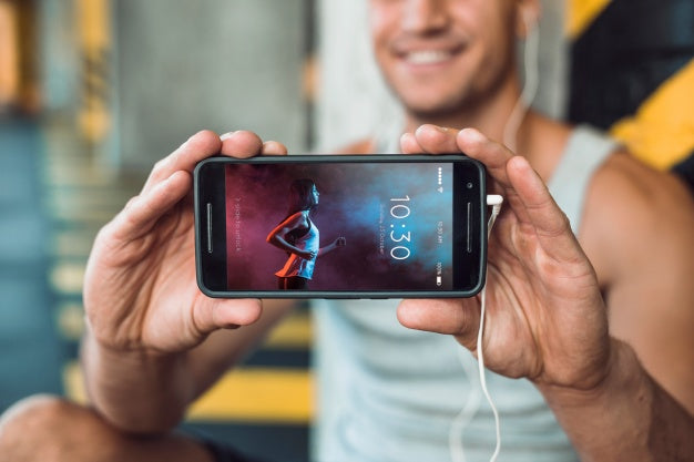 Man In Gym Holding Smartphone Mockup Psd
