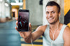 Man In Gym Holding Smartphone Mockup Psd