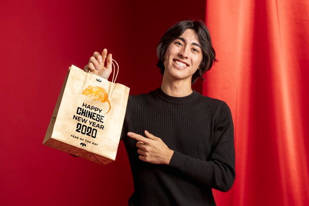 Man Pointing At Bag With Happy New Year Message Psd