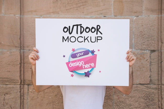 Man Presenting Poster Mockup In Front Of Brick Wall Psd