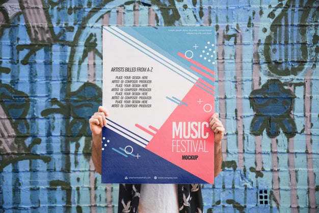 Man Presenting Poster Mockup In Front Of Graffiti Wall Psd