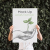 Man Presenting Poster Mockup In Front Of Leaves Psd