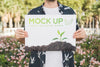 Man Presenting Poster Mockup In Front Of Park Psd