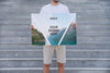 Man Presenting Poster Mockup In Front Of Stairs Psd