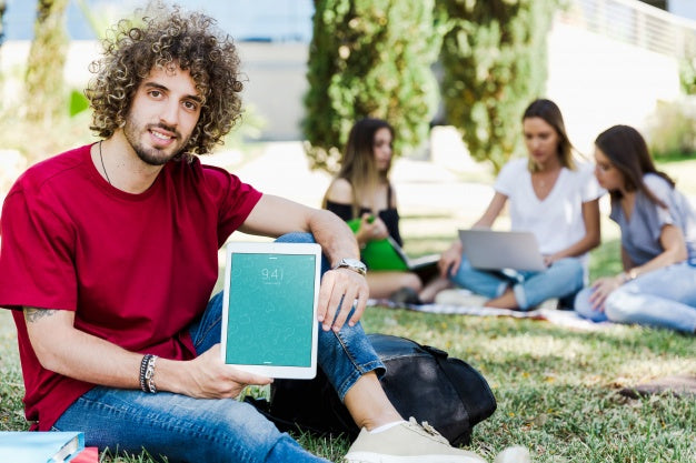 Man Showing Tablet Mockup In Park Psd