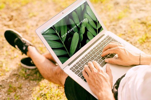 Man Using Laptop Mockup In Nature Psd