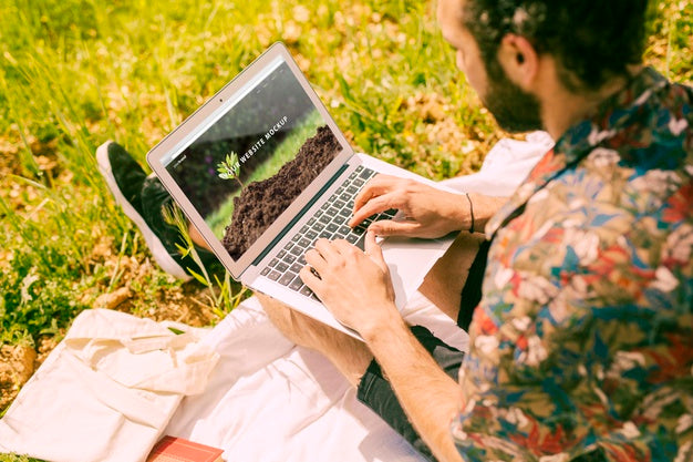 Man Using Laptop Mockup In Nature Psd