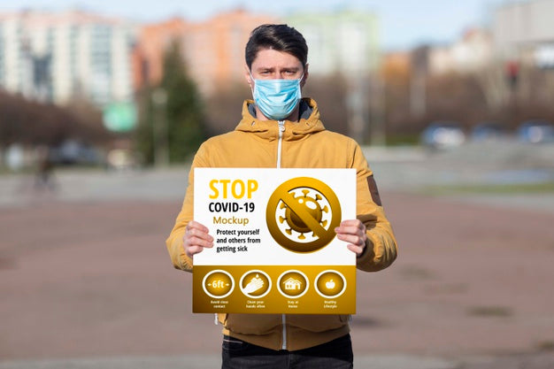 Man Wearing A Mask Holding A Coronavirus Stop Mock-Up Psd