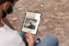 Man With Mask On Street Reading Book On Tablet Psd