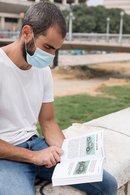 Man With Mask On Street Reading Book Psd