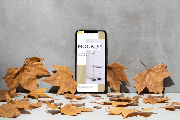 Mobile Phone Mockup Leaning On The Wall Surrounded By Leaves Psd