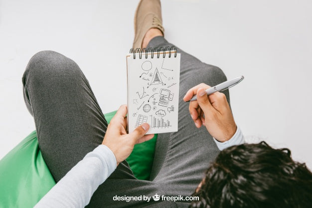 Mock Up With Relaxed Man Drawing On The Notebook Psd