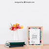 Mockup Of Frame Next To Plant On Books Psd