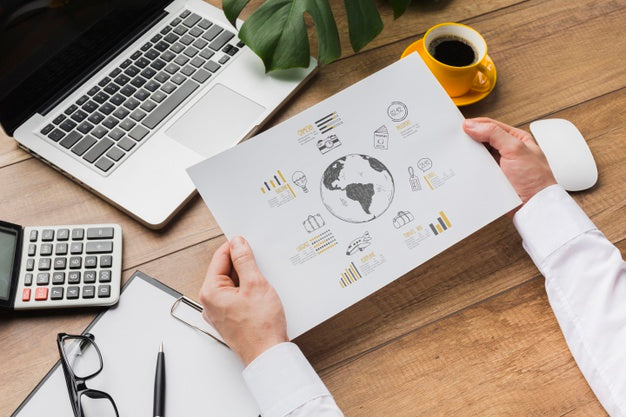 Office Desk With Person Holding Sheet Of Paper Mock-Up Psd