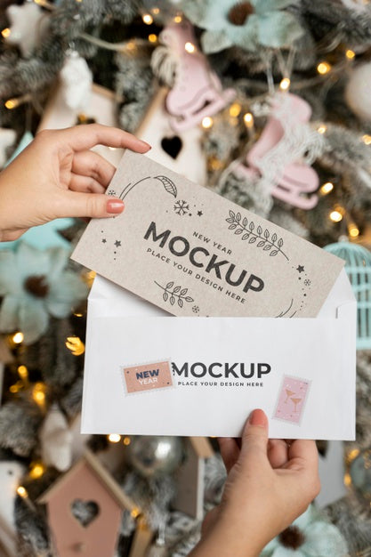 Person Holding Card With Envelope Next To Christmas Decorations Psd
