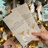Person Holding Mock-Up Cards In Front Of Christmas Decorations Psd