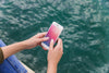 Person Using Smartphone Mockup On Sea Background Psd