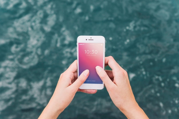 Person Using Smartphone Mockup On Sea Background Psd