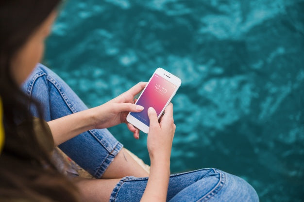 Person Using Smartphone Mockup On Sea Background Psd
