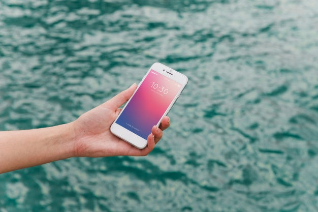 Person Using Smartphone Mockup On Sea Background Psd