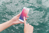 Person Using Smartphone Mockup On Sea Background Psd