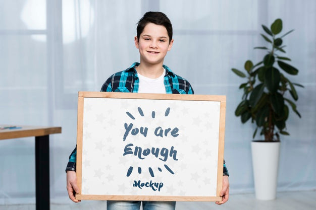 Portrait Of Positive Child Holding Mock-Up Sign Psd