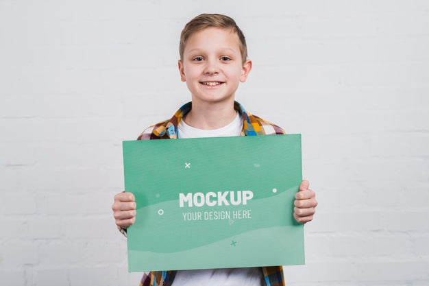 Portrait Of Smiley Kid Holding Mock-Up Sign Psd