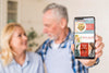Senior Couple In Kitchen Holding Phone Mock-Up Psd