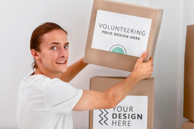 Side View Of Male Volunteer Handling Boxes With Donations Psd