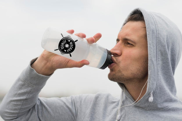 Side View Of Man Drinking Water While Working Out Psd
