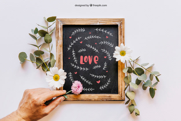 Slate Mockup With Hand Placing Flowers Psd