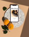 Smartphone With Citrus And Leaves Psd